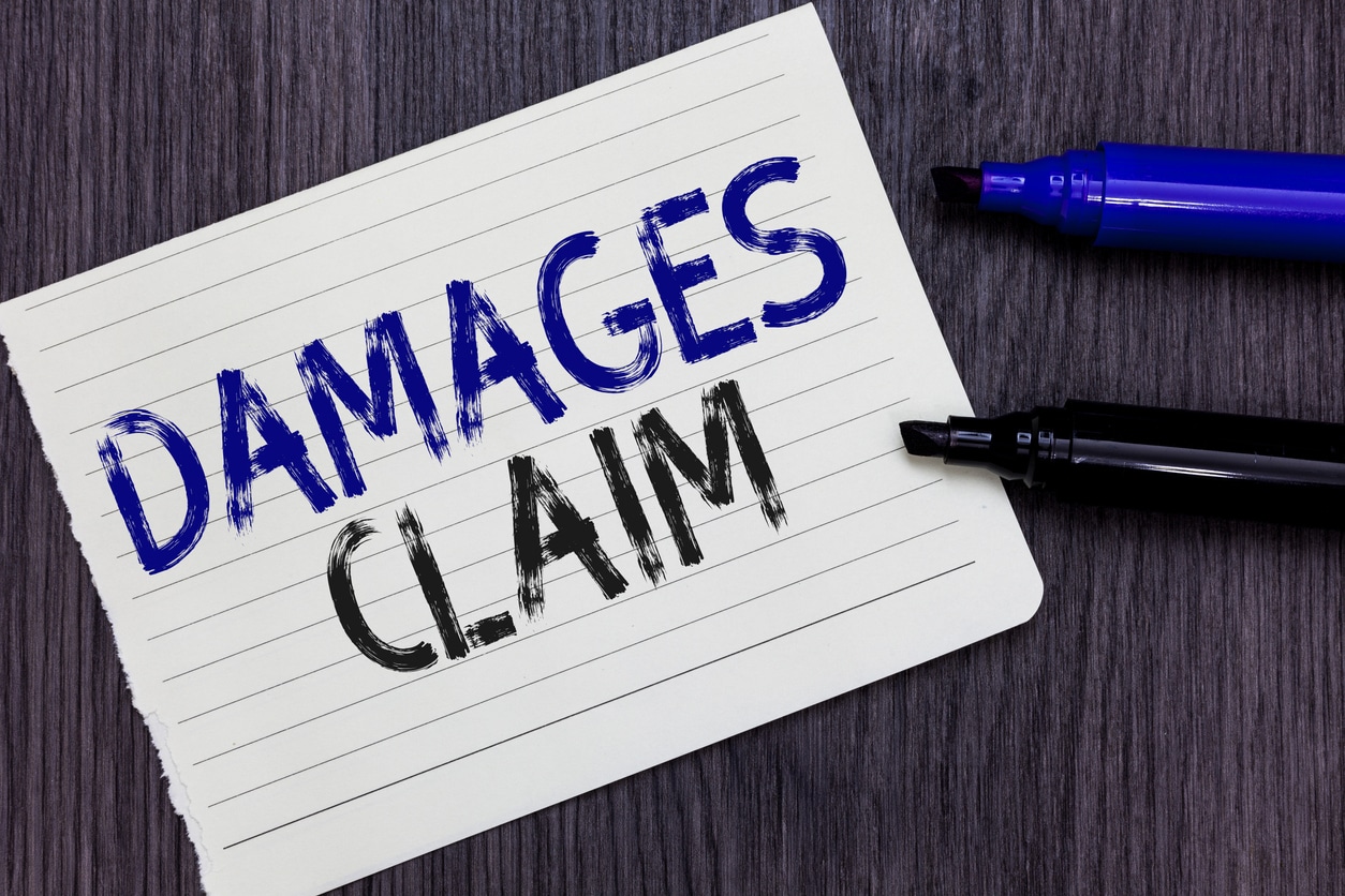 Writing note showing Damages Claim. Business photo showcasing Demand Compensation Litigate Insurance File Suit Notebook Paper Reminder Communicating ideas Markers Wooden background.